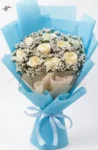 soft-blue-wrapping-white-flower-bouquet-roses-statice-gift