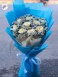 soft-blue-wrapping-white-flower-bouquet-roses-statice-gift